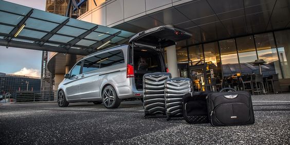 Airport transfer vehicle with luggage outside the terminal